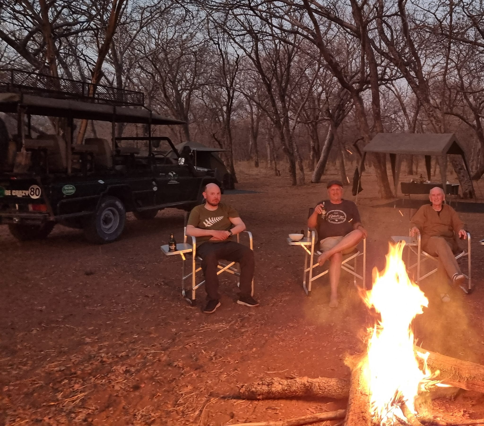 Guests and guide beside a safari vehicle in Botswana